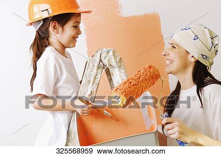 Close-up of a mature woman and her daughter painting a wall View Large Photo Image Stock Photo - Close-up of a mature woman and her daughter painting a wall. Fotosearch