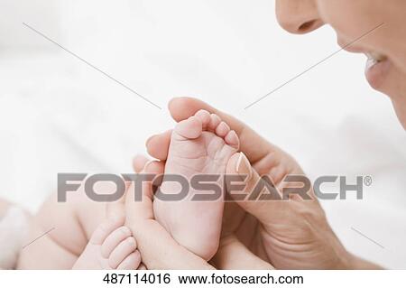 Close-up of a mature woman holding her baby's legs View Large Photo Image Stock Photograph - Close-up of a mature woman holding her baby's legs. Fotosearch