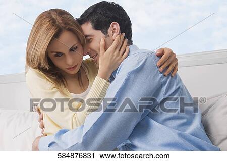 Stock Image - Close-up of a mid adult couple embracing each other. Fotosearch