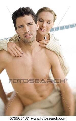 Stock Photo - Close-up of a mid adult couple romancing at poolside. Fotosearch