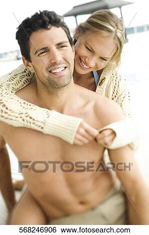 Stock Photograph - Close-up of a mid adult couple romancing at poolside. Fotosearch