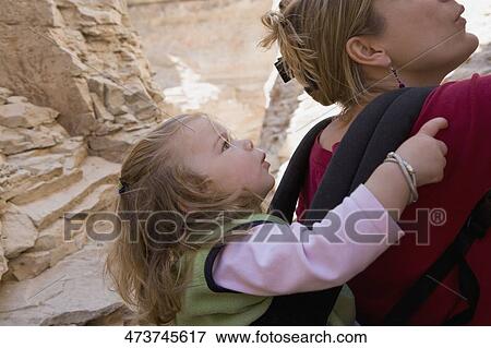 Close-up of a mid adult woman carrying her daughter in a baby carrier View Large Photo Image Stock Photo - Close-up of a mid adult woman carrying her daughter in a baby carrier. Fotosearch