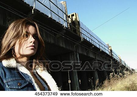 Close-up of a mid adult woman standing under an overpass View Large Photo Image Stock Photo - Close-up of a mid adult woman standing under an overpass. Fotosearch
