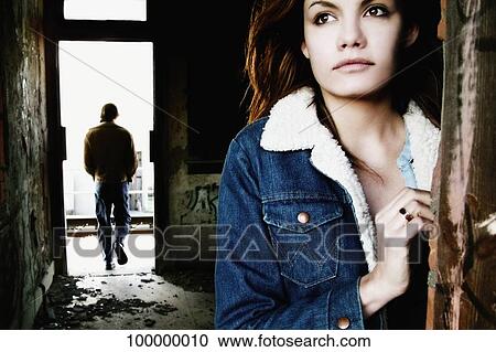 Close-up of a mid adult woman thinking with a mid adult man in the background View Large Photo Image Stock Image - Close-up of a mid adult woman thinking with a mid adult man in the background. Fotosearch