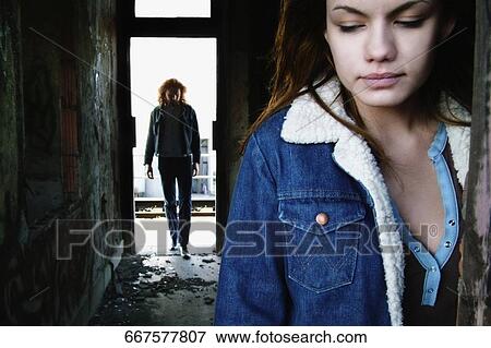 Close-up of a mid adult woman thinking with a mid adult man in the background View Large Photo Image Stock Photo - Close-up of a mid adult woman thinking with a mid adult man in the background. Fotosearch
