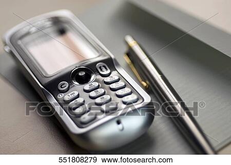 Close-up of a mobile phone and a ballpoint pen on a sheet of paper View Large Photo Image Stock Photo - Close-up of a mobile phone and a ballpoint pen on a sheet of paper. Fotosearch