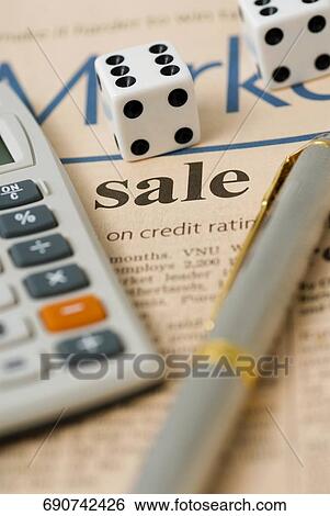 Close-up of a pen with a dice and a calculator on a financial newspaper View Large Photo Image Stock Photograph - Close-up of a pen with a dice and a calculator on a financial newspaper. Fotosearch