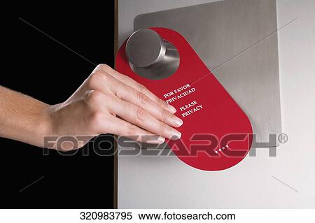 Close-up of a person's hand hanging do not disturb sign on a door handle View Large Photo Image Stock Photography - Close-up of a person's hand hanging do not disturb sign on a door handle. Fotosearch