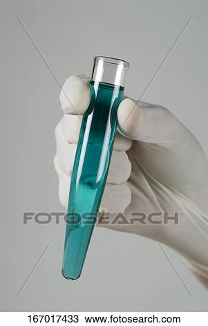 Stock Image - Close-up of a person's hand holding a test tube. Fotosearch