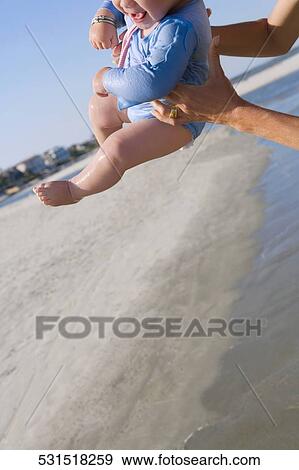 Close-up of a person's hand holding a baby in air View Large Photo Image Stock Photo - Close-up of a person's hand holding a baby in air. Fotosearch