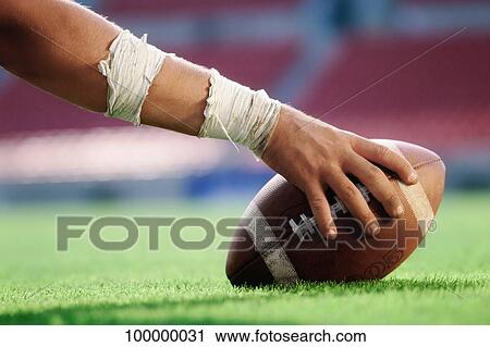 Close-up of a person's hand holding an American football View Large Photo Image Stock Image - Close-up of a person's hand holding an American football. Fotosearch