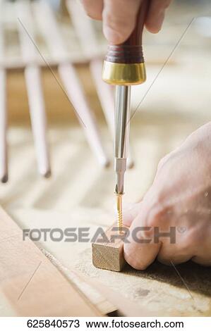 Close-up of a person's hand tightening a screw with a screwdriver View Large Photo Image Stock Image - Close-up of a person's hand tightening a screw with a screwdriver. Fotosearch