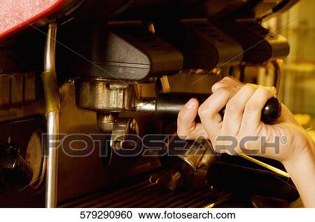 Close-up of a person's hand using a coffee maker View Large Photo Image Stock Image - Close-up of a person's hand using a coffee maker. Fotosearch