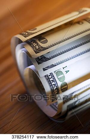 Stock Photo - Close-up of a roll of one hundred dollar bills. Fotosearch