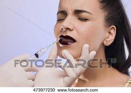 Close-up of a surgeon's hand injecting on a young woman's lips View Large Photo Image Stock Image - Close-up of a surgeon's hand injecting on a young woman's lips. Fotosearch