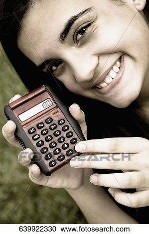 Close-up of a teenage girl showing a calculator View Large Photo Image Stock Image - Close-up of a teenage girl showing a calculator. Fotosearch