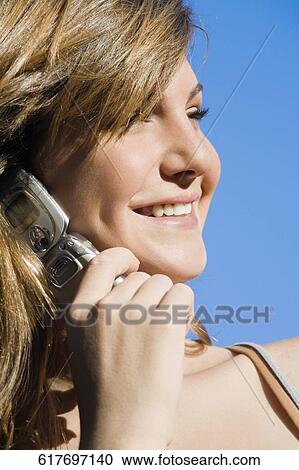 Close-up of a teenage girl talking on a mobile phone and smiling View Large Photo Image Stock Image - Close-up of a teenage girl talking on a mobile phone and smiling. Fotosearch