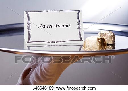 Close-up of a waiter's hand carrying a plate with sweet dreams note and chocolates View Large Photo Image Stock Photo - Close-up of a waiter's hand carrying a plate with sweet dreams note and chocolates. Fotosearch