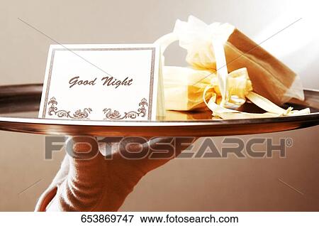 Close-up of a waiter's hand holding a good night note in a plate View Large Photo Image Stock Photo - Close-up of a waiter's hand holding a good night note in a plate. Fotosearch