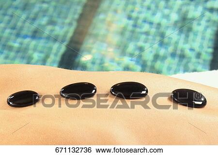 Close-up of a woman getting hot stone therapy View Large Photo Image Stock Photograph - Close-up of a woman getting hot stone therapy. Fotosearch