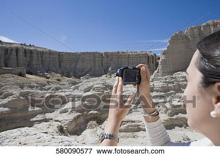 Stock Photo - Close-up of a woman photographing with a digital camera. Fotosearch