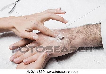 Close-up of a woman's hand applying lotion on a man's hand View Large Photo Image Stock Photo - Close-up of a woman's hand applying lotion on a man's hand. Fotosearch