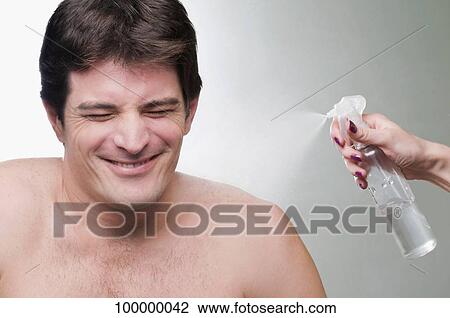 Close-up of a woman's hand spraying water on a mid adult man View Large Photo Image Stock Image - Close-up of a woman's hand spraying water on a mid adult man. Fotosearch