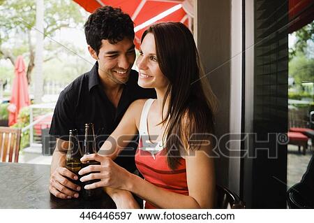 Close-up of a young couple holding beer bottles and smiling View Large Photo Image Stock Photo - Close-up of a young couple holding beer bottles and smiling. Fotosearch