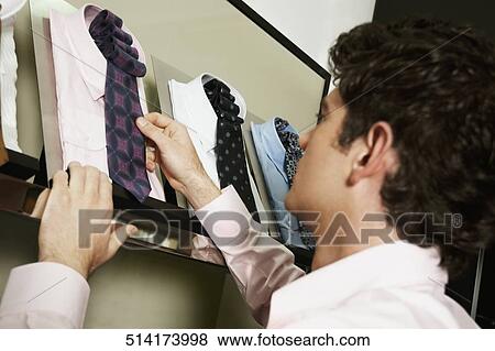 Close-up of a young man holding a shirts View Large Photo Image Stock Photo - Close-up of a young man holding a shirts . Fotosearch
