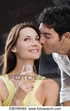 Stock Photography - Close-up of a young man kissing a young woman. Fotosearch