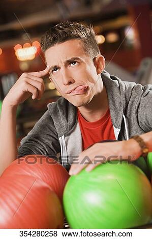 Close-up of a young man sticking his tongue out and thinking View Large Photo Image Stock Photo - Close-up of a young man sticking his tongue out and thinking. Fotosearch
