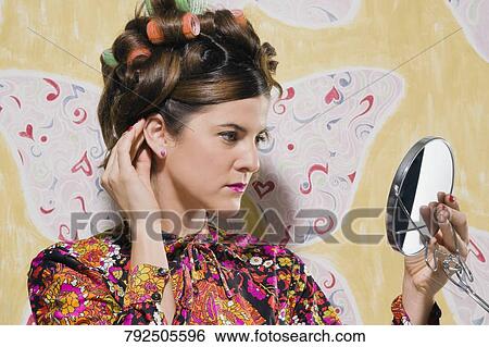 Close-up of a young woman adjusting her hair View Large Photo Image Stock Photograph - Close-up of a young woman adjusting her hair. Fotosearch