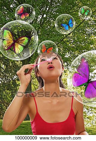 Close-up of a young woman blowing bubbles View Large Photo Image Stock Photo - Close-up of a young woman blowing bubbles. Fotosearch