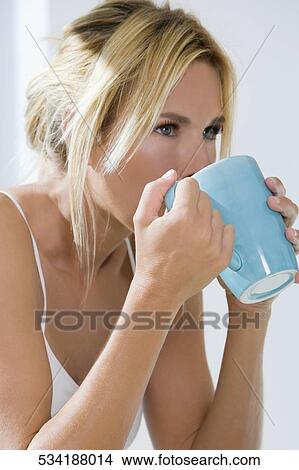 Close-up of a young woman drinking tea View Large Photo Image Picture - Close-up of a young woman drinking tea. Fotosearch