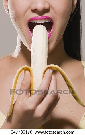 Close-up of a young woman eating a banana View Large Photo Image Stock Image - Close-up of a young woman eating a banana. Fotosearch