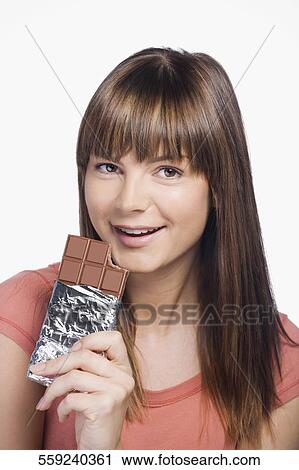 Close-up of a young woman eating a chocolate View Large Photo Image Stock Image - Close-up of a young woman eating a chocolate. Fotosearch
