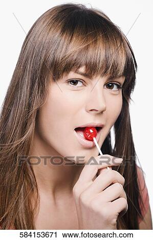 Close-up of a young woman eating a lollipop View Large Photo Image Stock Image - Close-up of a young woman eating a lollipop. Fotosearch