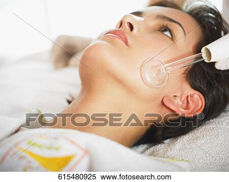 Close-up of a young woman getting a face massage View Large Photo Image Stock Photography - Close-up of a young woman getting a face massage. Fotosearch