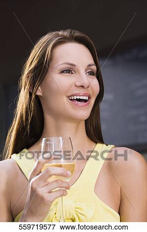Close-up of a young woman holding a wine glass View Large Photo Image Stock Photo - Close-up of a young woman holding a wine glass. Fotosearch