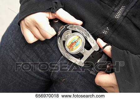 Close-up of a young woman holding her belt View Large Photo Image Stock Photo - Close-up of a young woman holding her belt. Fotosearch