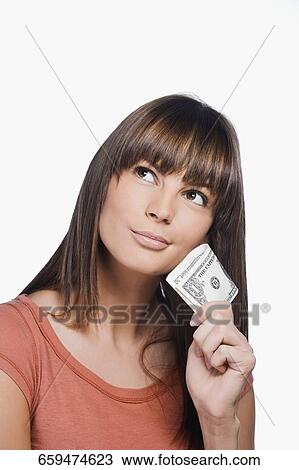 Close-up of a young woman holding one dollar bills and thinking View Large Photo Image Stock Image - Close-up of a young woman holding one dollar bills and thinking. Fotosearch