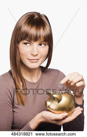 Close-up of a young woman inserting a coin into a piggy bank View Large Photo Image Stock Image - Close-up of a young woman inserting a coin into a piggy bank. Fotosearch