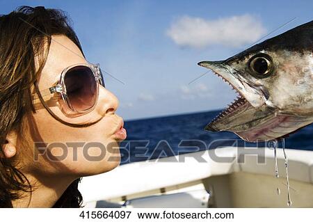 Stock Photo - Close-up of a young woman kissing a fish. Fotosearch