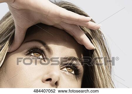 Close-up of a young woman shielding her eyes with her hands View Large Photo Image Stock Image - Close-up of a young woman shielding her eyes with her hands. Fotosearch