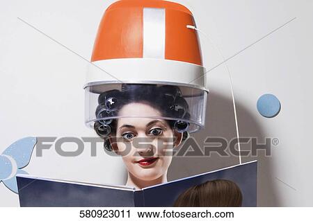 Close-up of a young woman sitting under hair dryer and reading a book View Large Photo Image Stock Image - Close-up of a young woman sitting under hair dryer and reading a book. Fotosearch