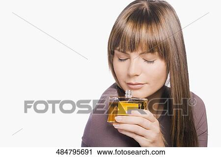Close-up of a young woman smelling perfume View Large Photo Image Stock Image - Close-up of a young woman smelling perfume. Fotosearch