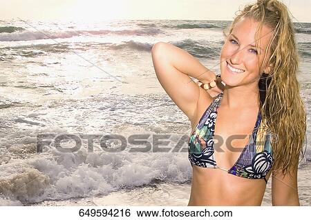 Stock Photograph - Close-up of a young woman smiling on the beach. Fotosearch