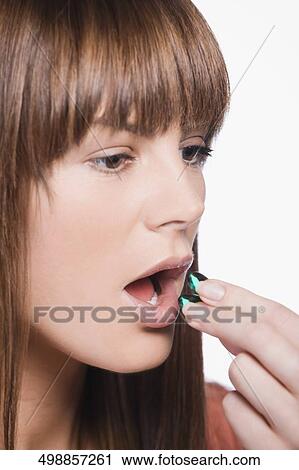 Close-up of a young woman taking pills View Large Photo Image Stock Image - Close-up of a young woman taking pills. Fotosearch