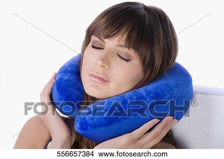 Close-up of a young woman using a neck pillow and sleeping View Large Photo Image Picture - Close-up of a young woman using a neck pillow and sleeping. Fotosearch