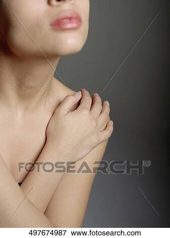 Stock Photo - Close-up of a young woman with her arms crossed. Fotosearch